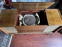 Top view of stereo console open showing turntable and tonearm inside wooden cabinet