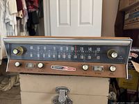 Front view of Heathkit vintage radio tuner showing AM/FM dial, woodgrain front, control knobs, and band selection.