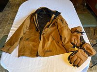 Full view of Dakota jacket and Carhartt gloves on table
