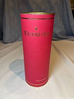 Red cylindrical Waterford box standing upright