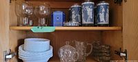 Full view showing variety of items including dishes, bowls, glassware, and containers on shelves