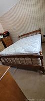 Maple wood double bedframe with mattress and box set, showing the side and headboard with spindle design