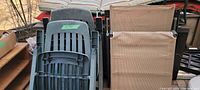 Folded green plastic lounge chairs stacked upright showing fading due to sun exposure.