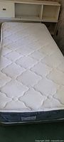Photo of the twin mattress showing white quilted surface without stains.