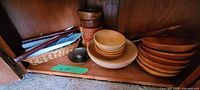 Six wooden bowls including large bowl and smaller bowls, two nut bowls, basket with utensils on shelf