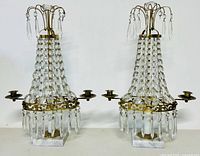 Pair of vintage French 2-head candelabras made with brass, crystal bead strands, and marble bases seen from front on white background.