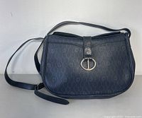 Full frontal view of Christian Dior black leather crossbody bag, displaying signature pattern and buckle detail.