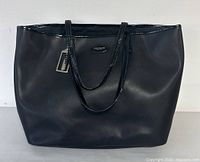 Full front view of the black COACH tote bag showing its shape and structure.