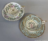 Two vintage Paragon teacups with matching saucers, floral motif with gold embellishments and Queen Elizabeth II coronation symbols visible.