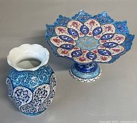 Photo showing both the footed cookie bowl with intricate enameling and the matching vase with floral patterns.