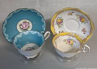 Two vintage Royal Albert teacup and saucer sets side by side, showing color and pattern contrast.