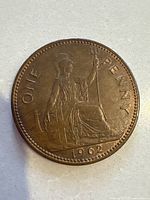 Reverse side of the 1962 UK one penny coin showing Britannia seated with trident and shield