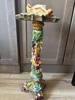 Full height front view of the resin Asian Art antique ashtray, showing the carved base with dragon face, the pillar with colorful standing figure, and the wide ashtray top.