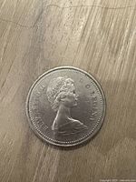 Obverse side of the 1975 Canadian silver dollar coin showing Queen Elizabeth II's portrait and inscriptions.