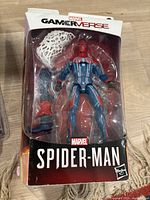 Front view of the Marvel Gamerverse Spider-Man figure in packaging. Shows the figure in blue and red suit with web accessory and alternate hand.