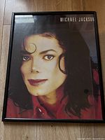 Full view of framed Michael Jackson photographic poster on floor surface, showing entire front and frame