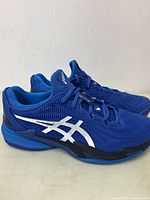 Side view of blue ASICS men's running shoes showing the design and color with white logo.