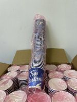 Stack of blue and white Tim Hortons small paper cups with holiday design and logo, wrapped in plastic