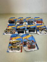 Lot of 10 Hot Wheels cars in original packaging with visible minor damage to some packs