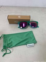 Knockaround sunglasses laid out with original box and soft pouch on white surface