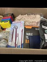 Photo of a box containing Oracare dental tools, table tennis balls, beige silicone molds, and assorted packaged items