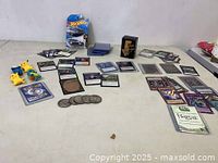 Assorted collectible cards spread out with Pokemon figures and a Hot Wheels car in packaging