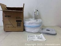 Spin mop system components including bucket, mop handle, mop head, microfiber pads, and instruction manual, all new in box.