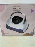 Front view of sealed box showing the LKEnail SUN X9 Max nail lamp image and branding with pastel pink design and device features