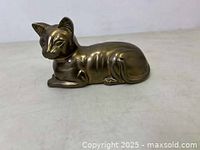Side and front view of the vintage brass cat paperweight showing detailed features and polished brass surface.