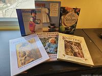 The collection of 6 knitting and stitching guide books laid out on a surface showing varied cover designs and titles.