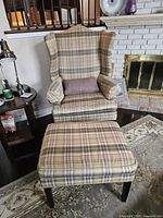 Front view of chair with ottoman and throw cushion visible