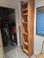 Full side angle view of tall solid pine bookcase showing shelves and wood grain.