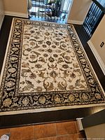 Full view of rug laid on hardwood floor showing overall pattern and border