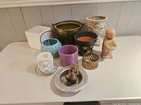 12 patio accessories including various pots, wine coaster, cork holder, and small figurine displayed on a white surface.