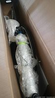 Partial view of bubble-wrapped bicycle frame and fork inside shipping box