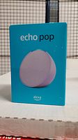 Front of Echo Pop box showing product image and name in teal packaging.