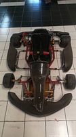Overhead view of red steel chassis with black front bumper, plastic seat and slick tires