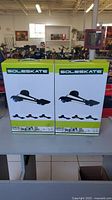 Front view of two boxed SoleSkate units showing brand name and image of the product on the box.