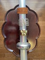 Photo showing three bracelets: brown leather embossed bracelet, silver-tone multi-strand open cuff, and chunky hammered silver-tone bangle on a dark wooden tray.