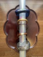 Six assorted bracelets displayed vertically on a stand, showing various colors and materials.