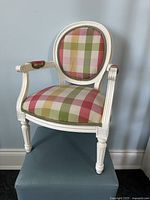 Front view of child size mini French Provincial bergere chair showing plaid upholstery and carved white wooden frame.