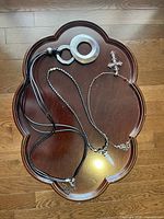 Photo of three necklaces on wood surface showing varying materials and pendants.