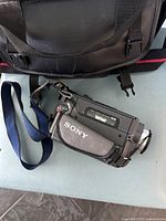 View of Sony Handycam Vision Hi8 camcorder with hand strap and part of carrying bag