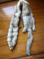 Grey mink fur scarf laid flat showing full length including tail and head with clasp detail.
