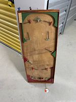 Full view of the antique tabletop hockey table showing the wooden frame, painted surface and metal peg controls.