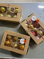 Top-down view of three boxed sets of mercury glass bulbs tied with string, showing price stickers and bulbs visible through window