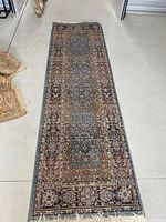 Full view of the entire hallway runner rug on the floor, showing length and border design.