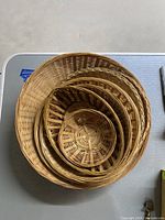 Top view of five nested round woven baskets showing weave pattern and sizes.