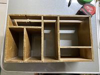 Top-down view of wooden shelf showing compartments and worn surface