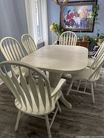 Overview of painted dining table with six chairs in room